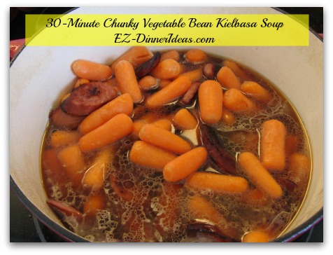 30-Minute Chunky Vegetable Bean Kielbasa Soup - Add carrots, broth/stock, tomatoes with juice, spices and herbs
