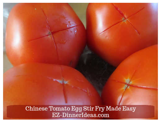 Cutting a cross at the bottom of each tomato Cutting a cross at the bottom of each tomato