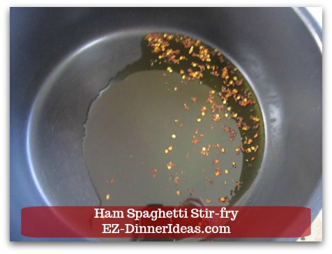 Ham Spaghetti Stir-Fry - Preheat extra virgin olive oil and crushed red pepper flakes in a big, deep skillet.