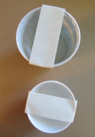 Stack 2 cups together.  Put a white painter tape across the cup, not too tight Stack 2 cups together.  Put a white painter tape across the cup, not too tight