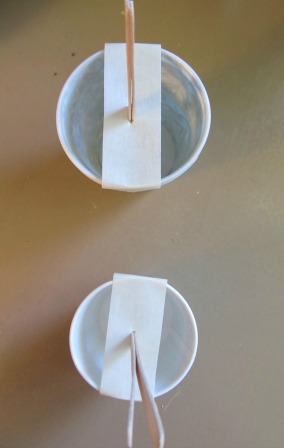 Cut a sliver on the tape lengthwise and put the popsicle stick through Cut a sliver on the tape lengthwise and put the popsicle stick through