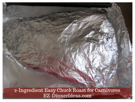 Chuck roast wrapped on the outer layer with aluminum foil after the parchment paper.