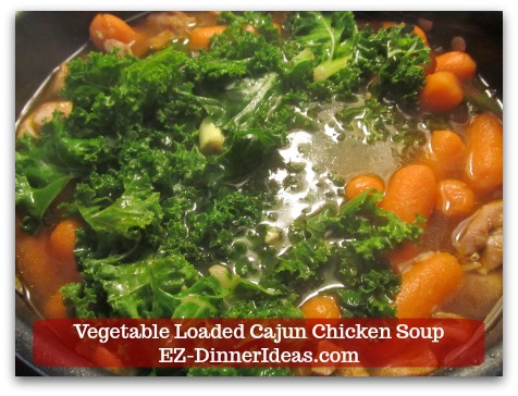 Kale Chicken Soup | Vegetable Loaded Cajun Chicken Soup - Stir in kale and use a spatula to press the vegetables down into the soup.